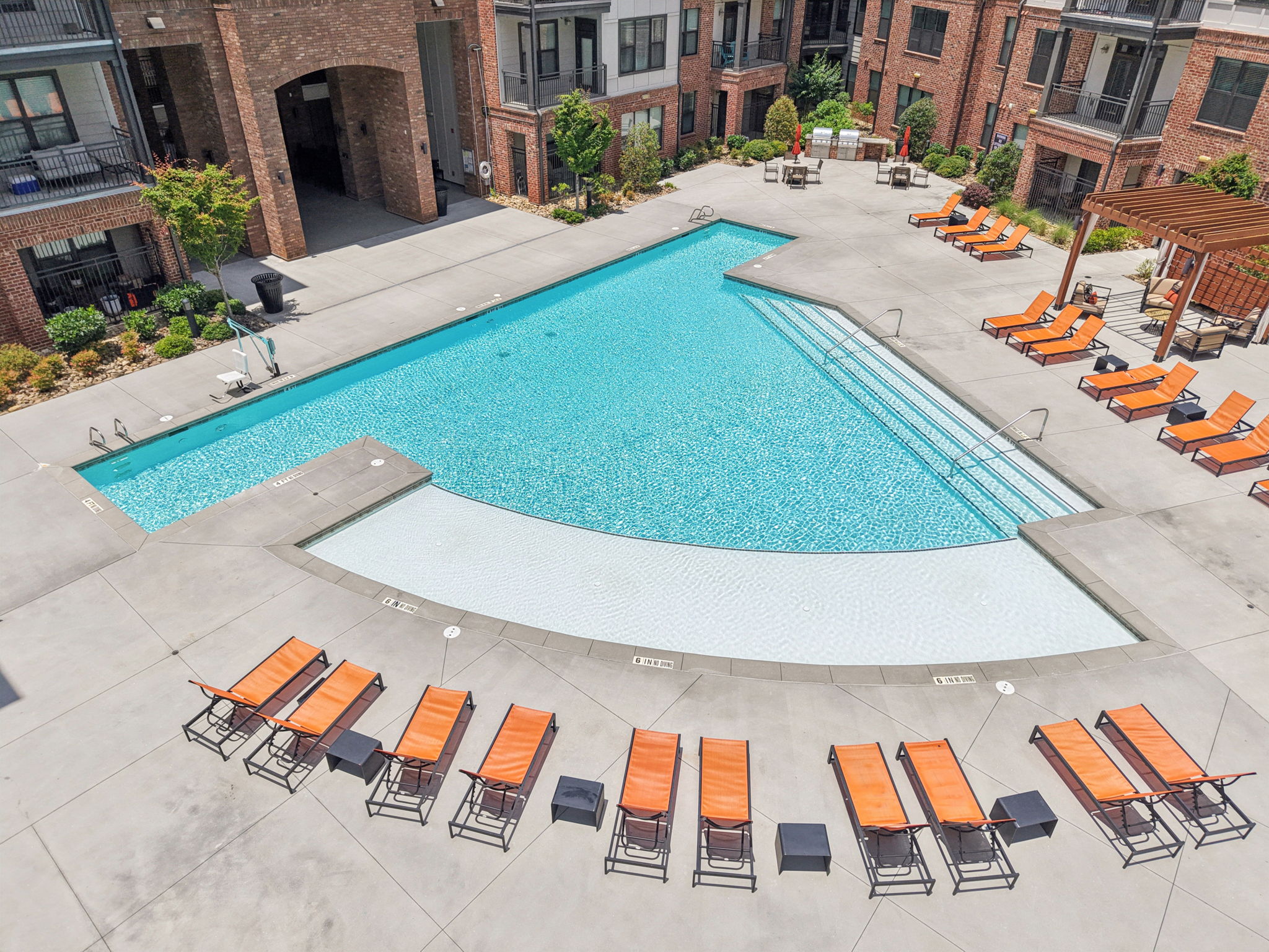 A swimming pool surrounded by orange lounge chairs.